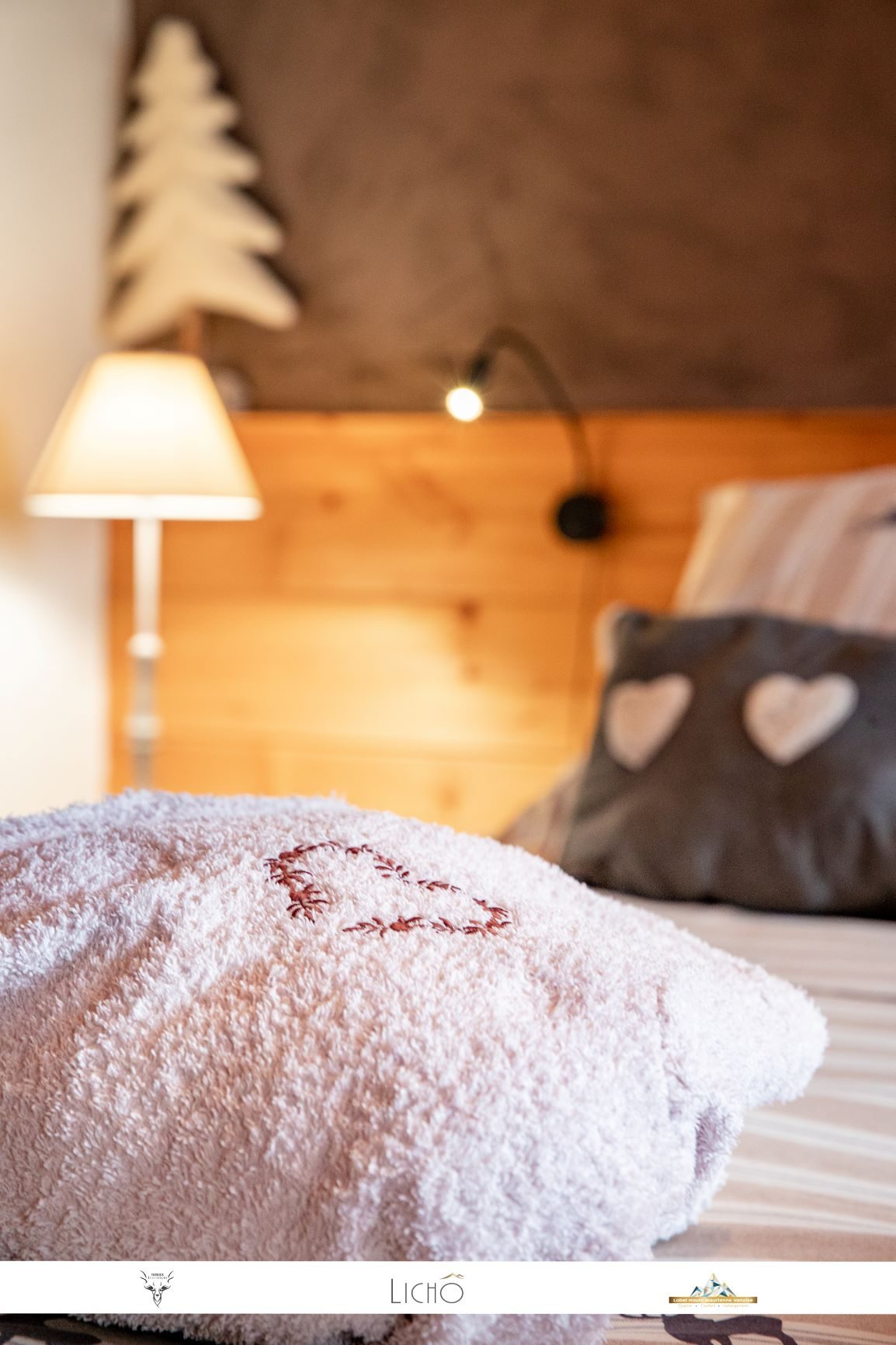 Serviette brodée d'un cœur posée sur le lit