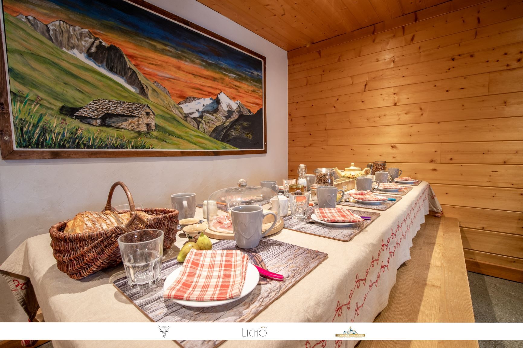 Table du petit déjeuner dressée sous un tableau de montagne